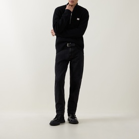 Model wearing Calvin Klein Jeans Badge Logo Waffle-Knit Half-Zip Sweatshirt in black, styled with black trousers and chunky boots.