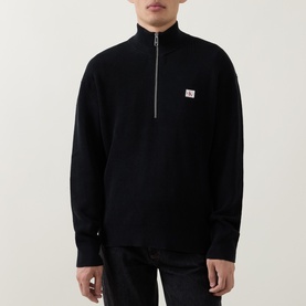 Model wearing Calvin Klein Jeans Badge Logo Waffle-Knit Half-Zip Sweatshirt in black with funnel neck and chest badge logo, styled with black