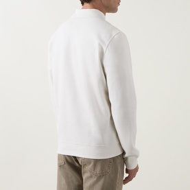 Model wearing Calvin Klein Jeans Tofu sweatshirt, rear view, ribbed cuffs and hem, styled with beige trousers