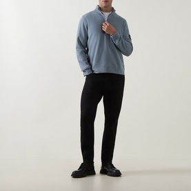 Model wearing Calvin Klein Jeans Steel Gray half-zip cotton sweatshirt, styled with black trousers and black chunky shoes.