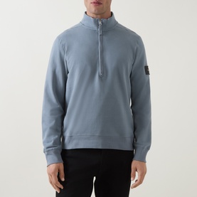 Model wearing Calvin Klein Jeans Steel Gray quarter-zip sweatshirt with stand collar and sleeve badge logo, styled with black trousers.