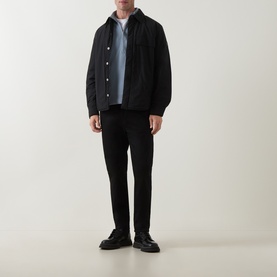 Model wearing Calvin Klein Jeans Steel Gray sweatshirt, styled with black quilted jacket and black slim-fit trousers