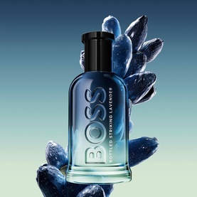 Hugo Boss Bottled Striking Lavender EDP in gradient blue-to-clear bottle with black cap, styled with deep blue botanical elements