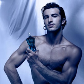 Model with Jean Paul Gaultier EDP fragrance bottle, shirtless male model in blue-toned campaign shot