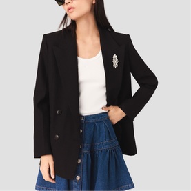 Model wearing Maje red blazer with crystal brooch detail, styled with white top and denim tiered mini skirt