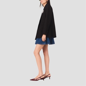 Model wearing Maje Womens French Dress in red, styled with a black oversized blazer and blue denim mini skirt, paired with dark red kitten heels.