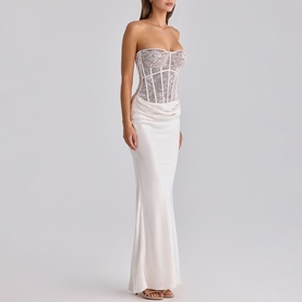 Model wearing House of CB white strapless maxi dress with sheer lace corset bodice and satin skirt
