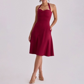 Model wearing House of CB wine halterneck fit-and-flare midi dress with sweetheart neckline, styled with nude heeled sandals