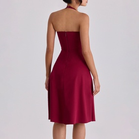 Model wearing House of CB wine halterneck midi dress, back view, featuring fitted bodice and flared skirt