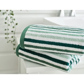 Deyongs Linear Stripe Towel Green, 100% cotton, folded stack showing white and multi-tone green horizontal stripes, styled in a bright bathroom