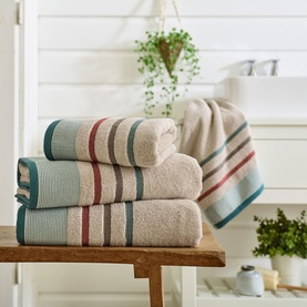 Deyongs Portland Stripe Towel Woodland in cream with teal and burgundy stripe borders, stacked with face cloths on wooden bench in bathroom setting.