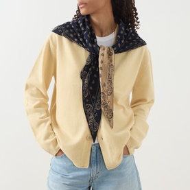 Model with Guest In Residence The Wild Rag Scarf in multi, paisley jacquard pattern tied at neck, styled with cream zip-up jacket