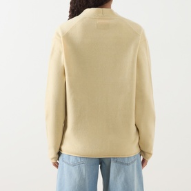 Model wearing Guest In Residence butter cashmere knit, back view, styled with light blue wide-leg jeans