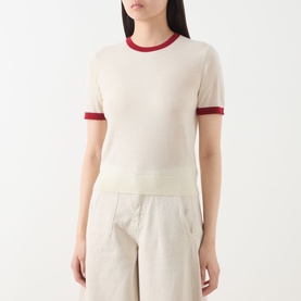 Model wearing Guest In Residence Airy Ringer T-Shirt in cream cashmere with contrast red ribbed trims, styled with wide-leg trousers