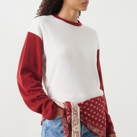 Model wearing Guest In Residence cashmere T-shirt in multi red and white colourblock, styled with blue jeans and paisley bandana
