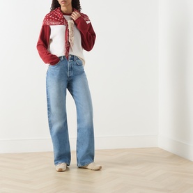 Model wearing Guest In Residence multi cashmere top styled with light blue wide-leg jeans and a red printed scarf