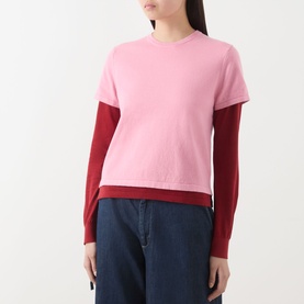 Model wearing Guest In Residence Double Layer Top in pink, featuring two-tone red underlayer sleeves and ribbed hemline, styled with navy wide-leg