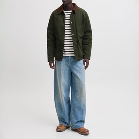 Model wearing Jack & Jones Norrebro Padded Barn Jacket in Rosin with contrast collar, styled with striped tee and wide-leg jeans.