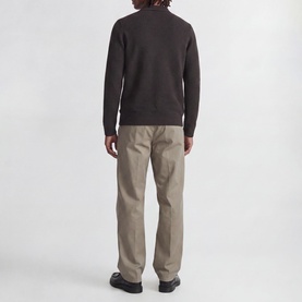 Model wearing Jack & Jones Riley Knitted Polo Shirt in Ganache, back view, styled with beige trousers and black shoes