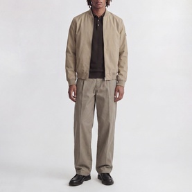 Model wearing Jack & Jones Riley Knitted Polo Shirt in Ganache, styled with a beige bomber jacket and matching trousers