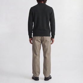 Model wearing Jack & Jones Riley Logo Knitted Polo Shirt in Scarab, back view, styled with beige straight-leg trousers