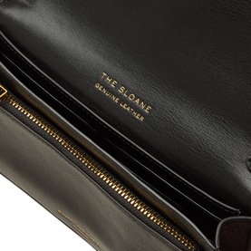 Kurt Geiger The Sloane black leather crossbody bag interior, showing smooth lining, card slots, and gold-tone zip detail