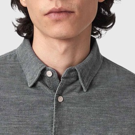 Model wearing All Saints light grey textured shirt, close-up showing collar and button detail