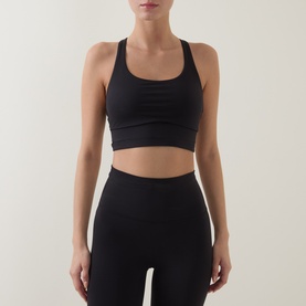 Model wearing Lululemon Energy Longline Sports Bra in black, styled with matching black high-waist leggings