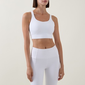 Model wearing Lululemon Energy Longline Bra in white, styled with matching white high-waist leggings