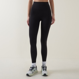 Model wearing Lululemon Wunder Train No Line High-Rise Tight 25" in black, styled with white ankle socks and grey trainers.