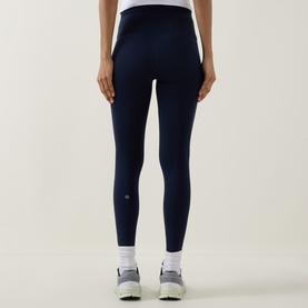 Model wearing Lululemon True Navy leggings, rear view, styled with white trainers. High-waisted fit with smooth, seamless back panel.