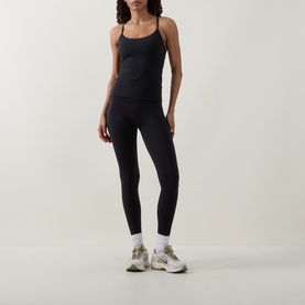 Model wearing Lululemon black leggings with matching black cami top, white ankle socks and grey trainers.