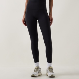 Model wearing Lululemon black high-waist leggings, styled with white ankle socks and grey trainers