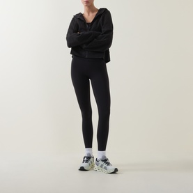Model wearing Lululemon Scuba Oversized Full-Zip Hoodie in black, styled with black leggings and white trail trainers