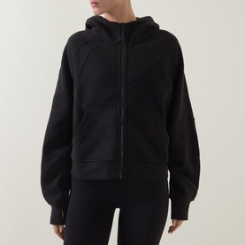Model wearing Lululemon Scuba Oversized Full-Zip Hoodie in black, with hood and zip fastening, styled with black leggings.