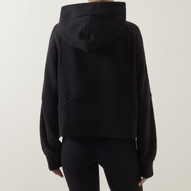 Model wearing Lululemon Scuba Oversized Full-Zip Hoodie in black, rear view, styled with black leggings