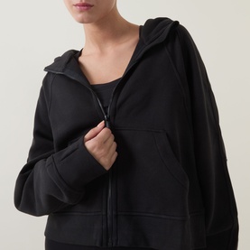 Model wearing Lululemon Scuba Oversized Full-Zip Hoodie in black, close-up showing zip detail and kangaroo pocket