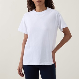 Model wearing Lululemon All Yours T-Shirt in white, relaxed fit with crew neck and short sleeves, styled with navy trousers