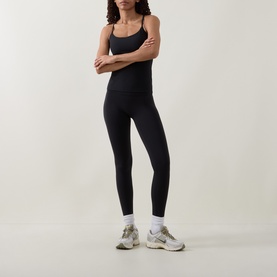 Model wearing Lululemon black cami top with matching black leggings and white trainers, arms crossed.