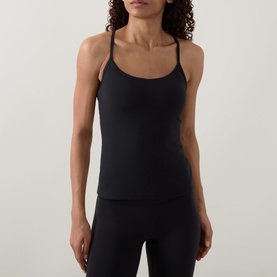 Model wearing Lululemon black fitted cami top with thin cross-back straps, styled with black leggings