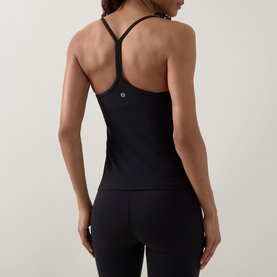 Model wearing Lululemon black racerback tank top, rear view showing Y-strap detail, styled with matching black leggings.
