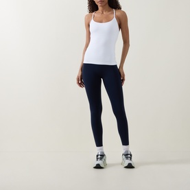 Model wearing Lululemon white cami top with thin straps, styled with navy leggings and white trainers.