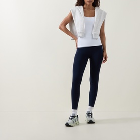 Model wearing Lululemon white sleeveless top with navy leggings and grey running trainers with white socks.