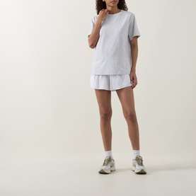 Model wearing Lululemon All Yours T-Shirt in Heathered Core Ultra Light Grey, styled with a white mini skirt and trainers.
