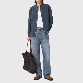 Model wearing All Saints moonstone blue shirt with white tee and light wash wide-leg jeans, carrying dark brown leather tote bag.
