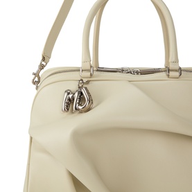 Marc Jacobs bone leather top handle bag, close-up showing structured silhouette, silver-tone hardware and branded charm detail