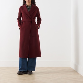 Model wearing Max Mara S bordeaux wool wrap coat with tie belt, styled with blue wide-leg trousers and black loafers.