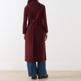Model wearing Max Mara S bordeaux wool wrap coat with self-tie belt, styled with wide-leg blue jeans, back view.