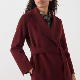 Model wearing Max Mara S bordeaux wool wrap coat with belt and notch lapels, styled with a floral print shirt.