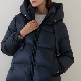 Model wearing Max Mara Cube midnight blue quilted hooded down coat with drawstring neckline, styled with grey knit top.